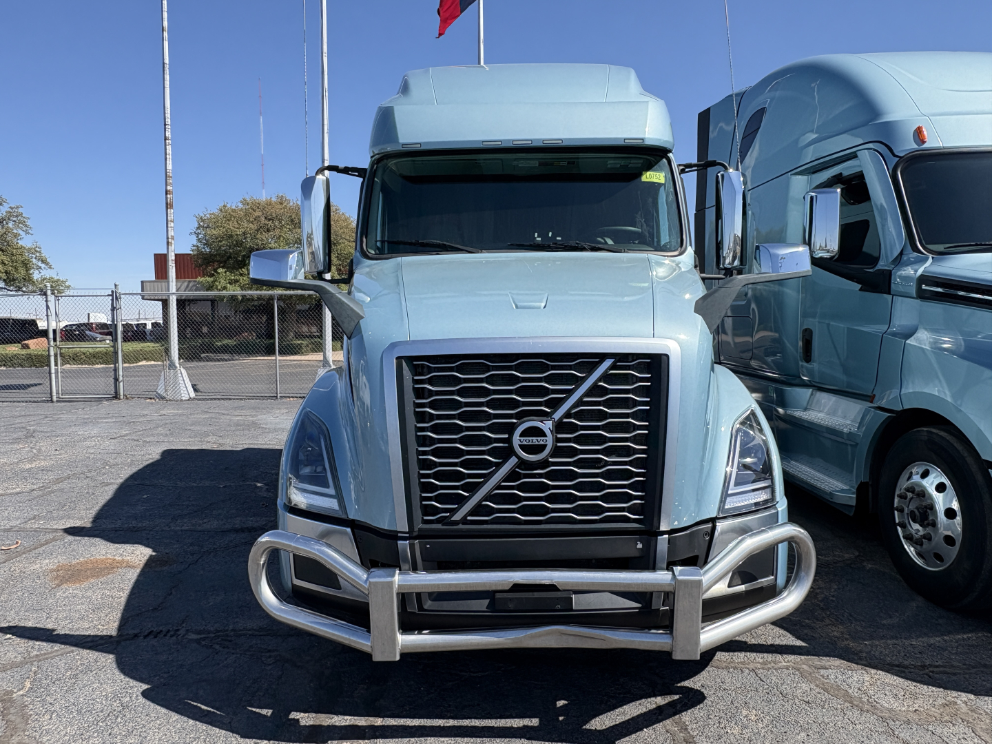 Front view of a blue 2022 Volvo VNL64T760 truck showing grille, bumper guard, and chrome mirrors.