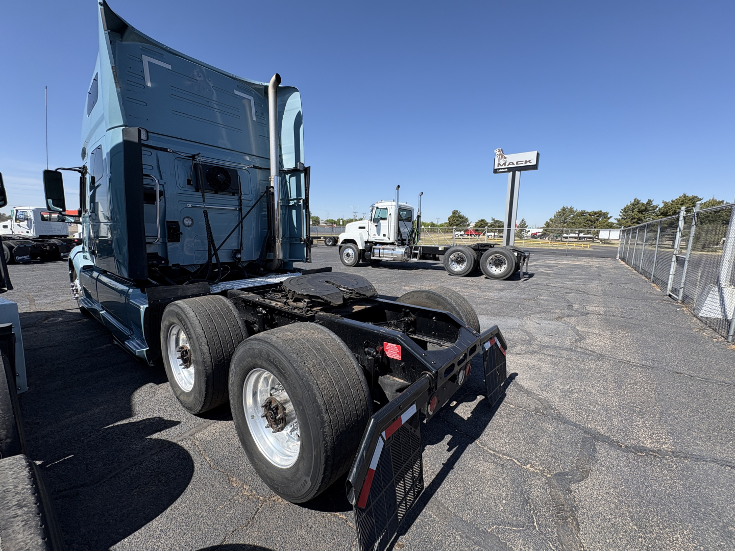 Volvo VNL64T760 tractor in a used truck lot showing rear chassis and dual rear axles.