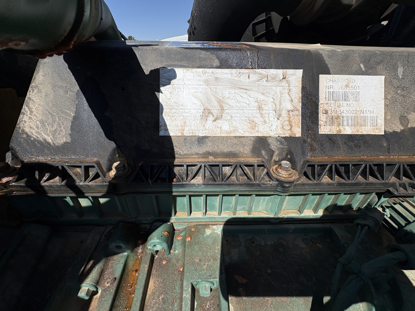 Exterior rear engine bay area of a used 2022 Volvo VNL64T760 showing a weathered top crossmember and faded label stickers.