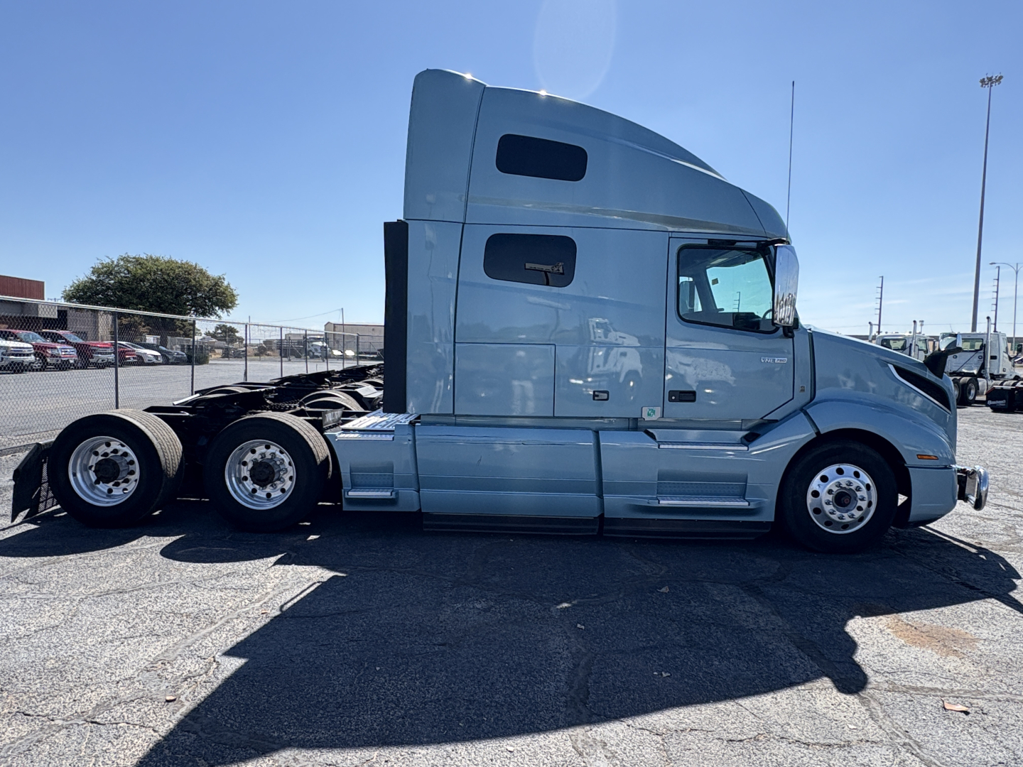 Volvo VNL64T760 sleeper cab tractor side profile showing two rear axles and aluminum wheels.