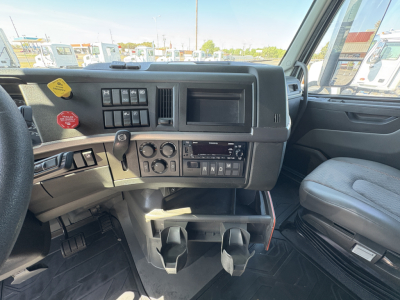  Volvo VNL64T760 dashboard view showing steering column, control cluster, cup holders, gear selector, and infotainment area.