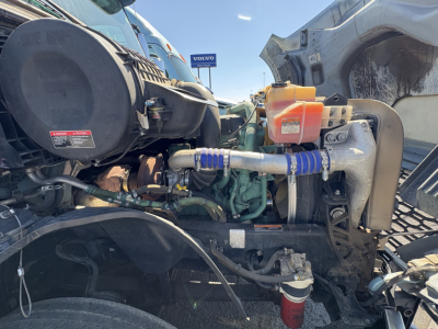 Volvo VNL64T760 engine bay showing diesel engine, coolant reservoir, hoses, and surrounding components.