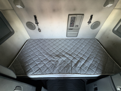Volvo VNL64T760 sleeper cab interior bunk area with quilted mattress pad and control panel on bulkhead
