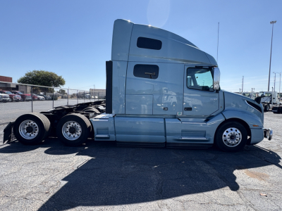 Volvo VNL64T760 sleeper cab tractor side profile showing two rear axles and aluminum wheels.
