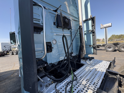 Volvo VNL64T760 truck sleeper cab side with steps and hydraulic lines visible, front of cab and equipment near door.