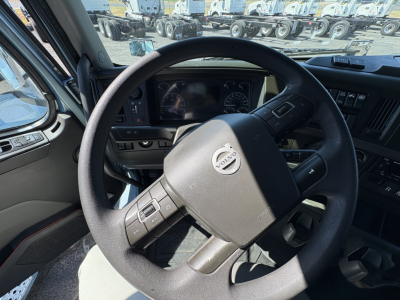 Volvo steering wheel and dashboard in-cab view of a 2022 Volvo VNL64T760 truck interior showing steering wheel with Volvo emblem and instrument cluster.