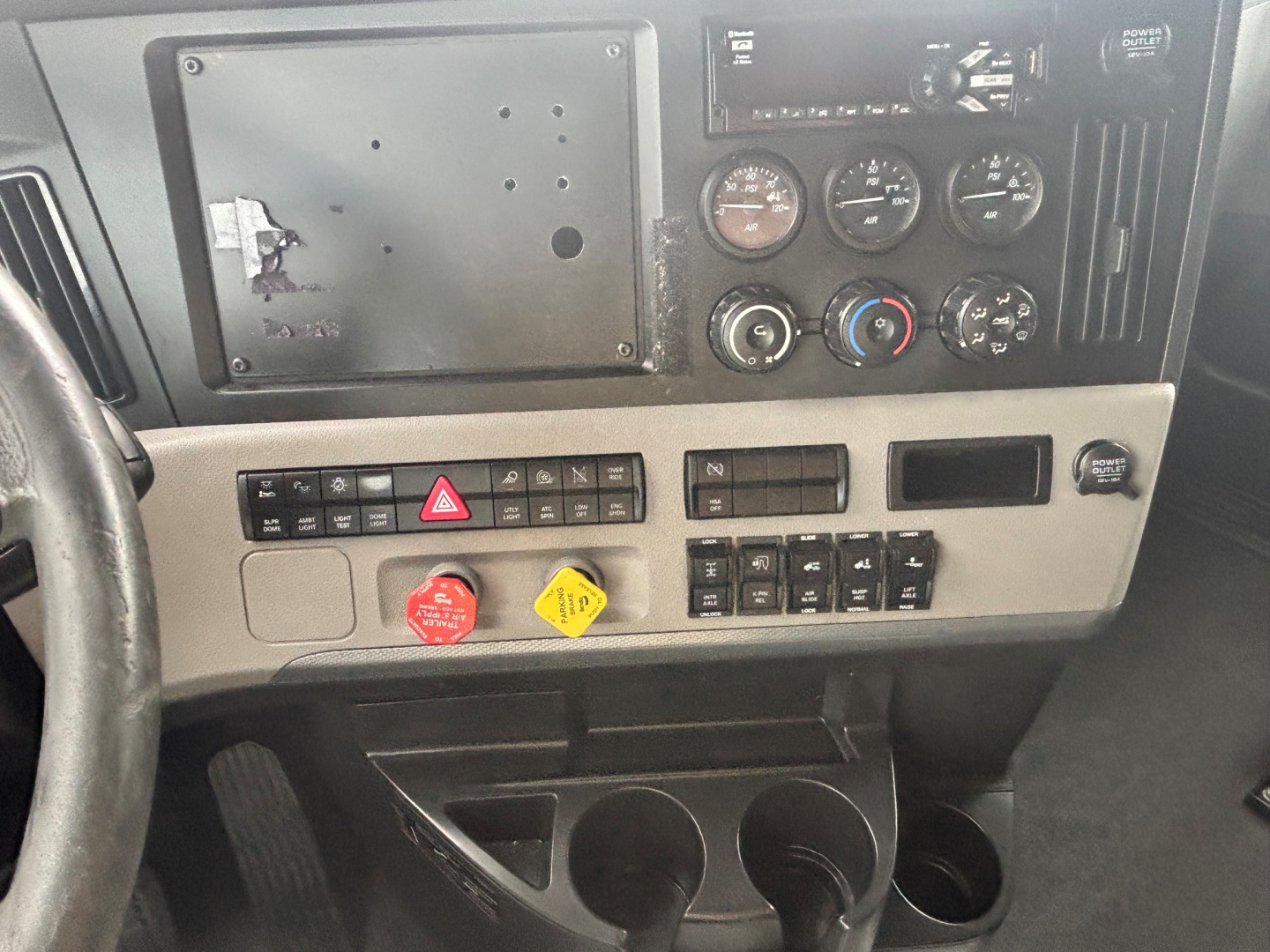 Cab interior of Freightliner CA-126 showing instrument cluster, climate controls, hazard switch, and cup holders.
