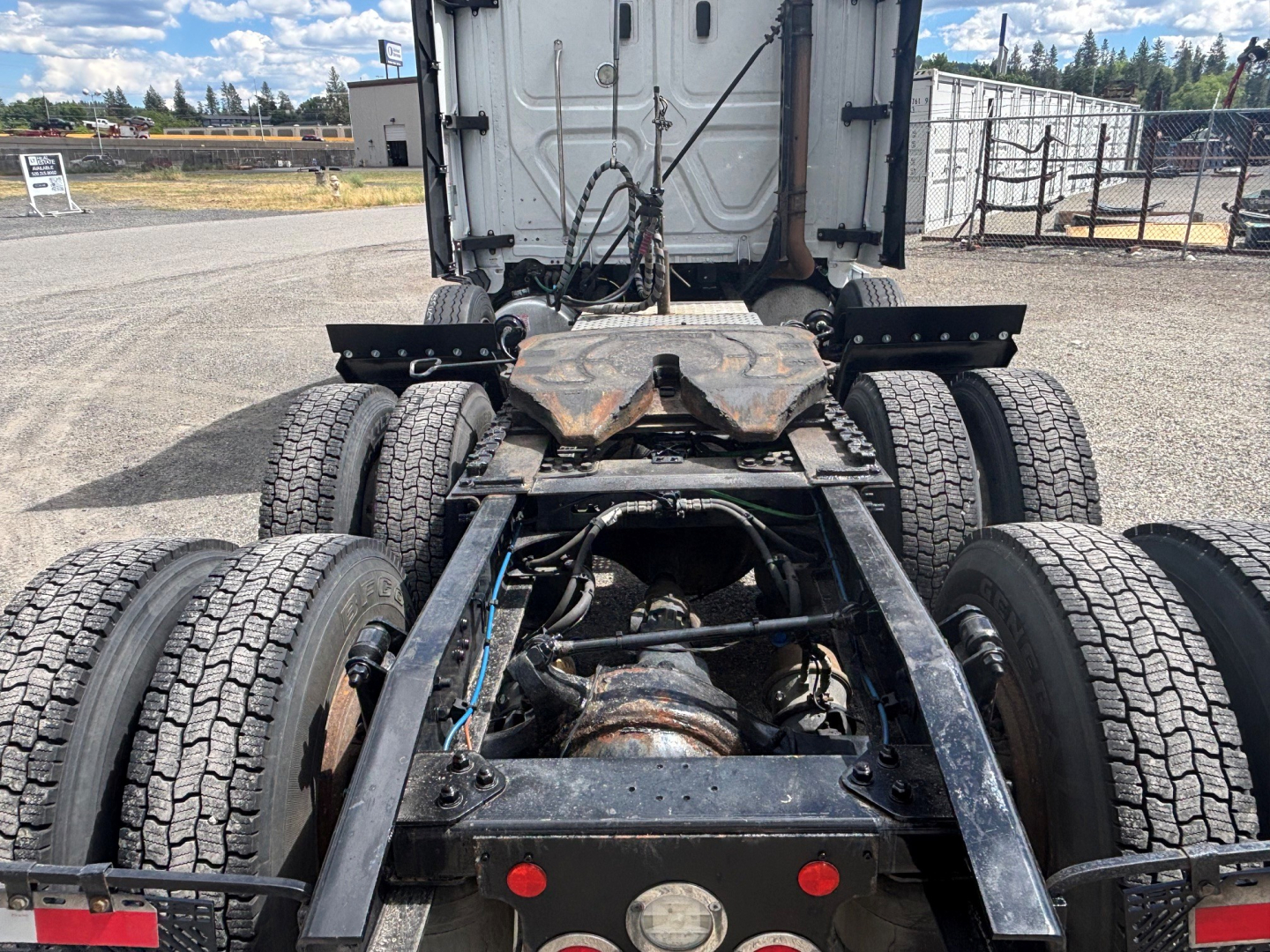 Truck chassis of a Freightliner CA-126 with rear view showing dual rear axles, driveshaft, and fifth wheel mounting area.