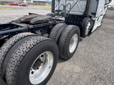 Freightliner CA-126 truck chassis showing dual rear axles and tires with metal rims, cab at rear, undercarriage and fifth wheel area visible.