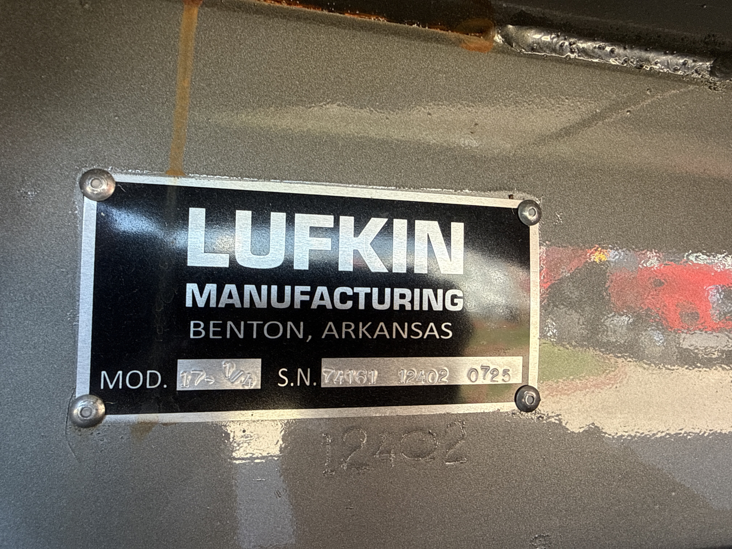 Label plate on Mack vehicle showing Lufkin Manufacturing Benton Arkansas with model and serial numbers (Mod. S.N. and other small text) in view.