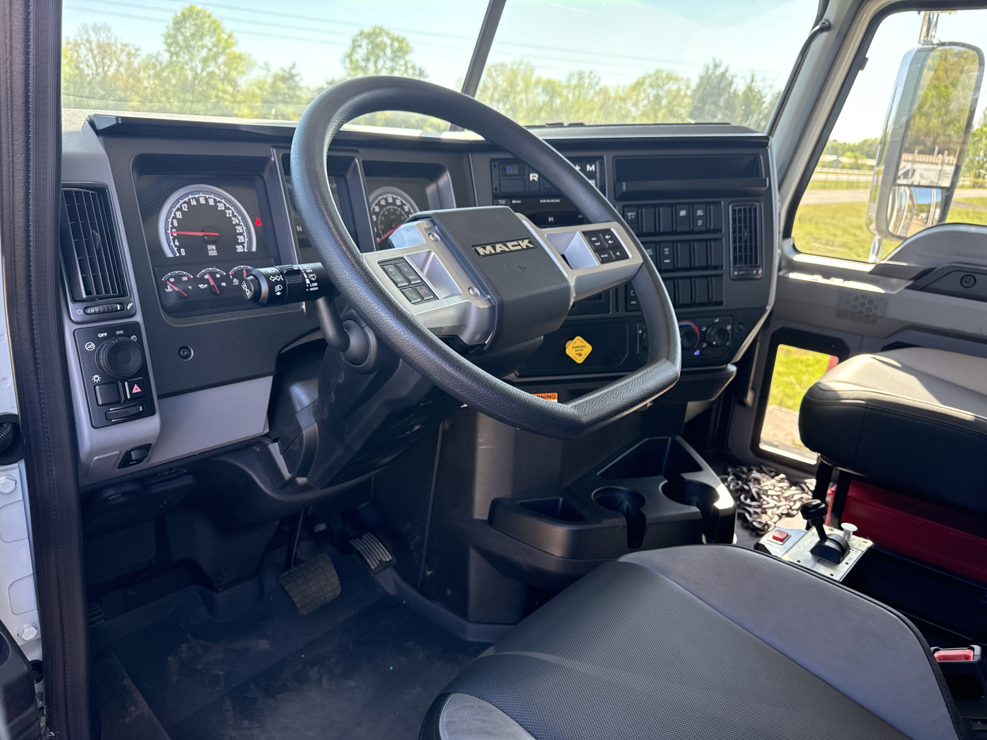 Mack GR84B truck interior showing steering wheel and dashboard with gauges and controls.