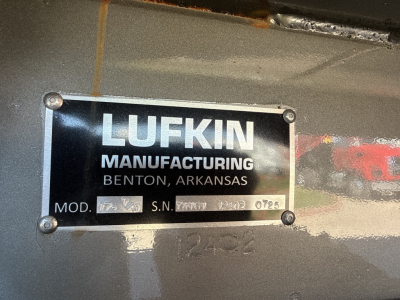Label plate on Mack vehicle showing Lufkin Manufacturing Benton Arkansas with model and serial numbers (Mod. S.N. and other small text) in view.