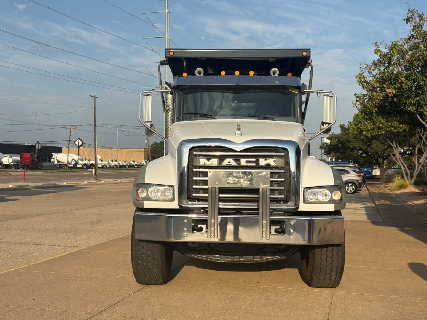 Front view of a 2021 Mack GR64F dump truck showing large chrome grille, Mack emblem, bumper guard, and dual front tires.