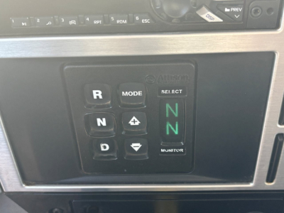 Truck gear selector panel with illuminated 'N' position and Mack Allsion controls in the cab of a 2021 Mack GR64F dump truck.