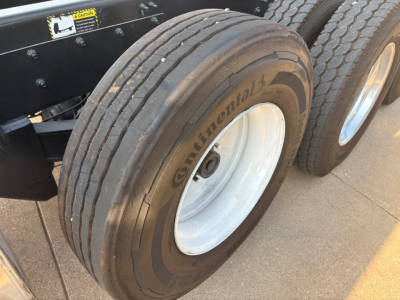 Continental tire and white wheel on Mack GR64F dump truck chassis, dual rear tires visible.