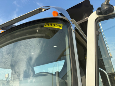 Mack GR64F cab windshield with yellow inventory tag B3434P visible atop the glass.