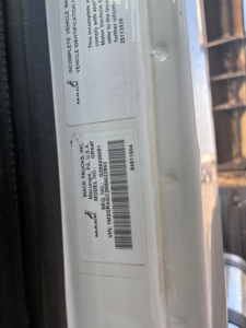 Mack GR64F DOT sticker and VIN label visible on door jamb with barcode and serial numbers