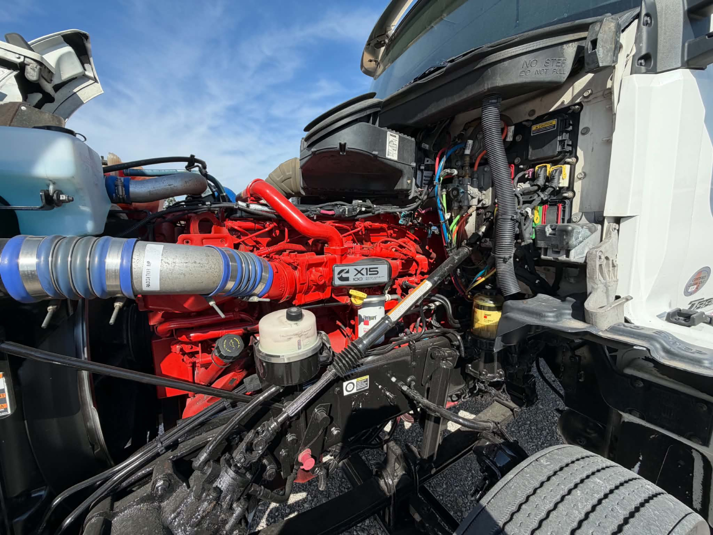 Kenworth T880 engine bay showing Cummins X15 engine and surrounding hoses and electricals.