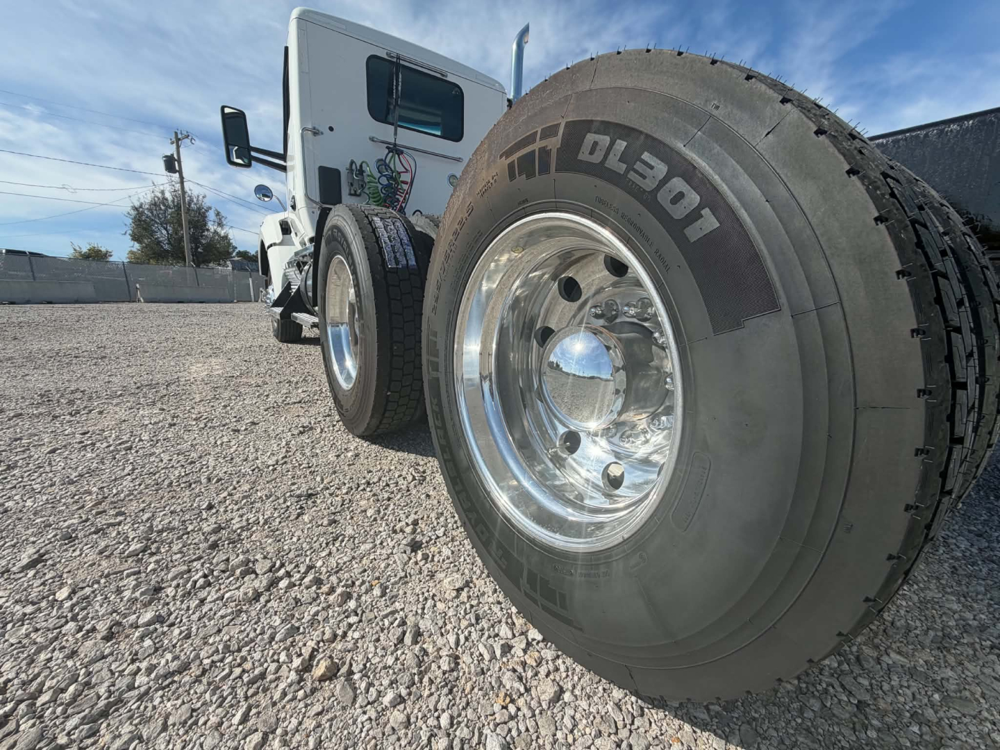 Kenworth T880 front wheel and side cab showing Goodyear Dura-? tire with chrome wheel and white cab.