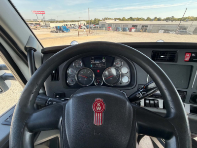 Kenworth T880 truck steering wheel and dashboard view from the driver seat showing instrument cluster and control stalks.