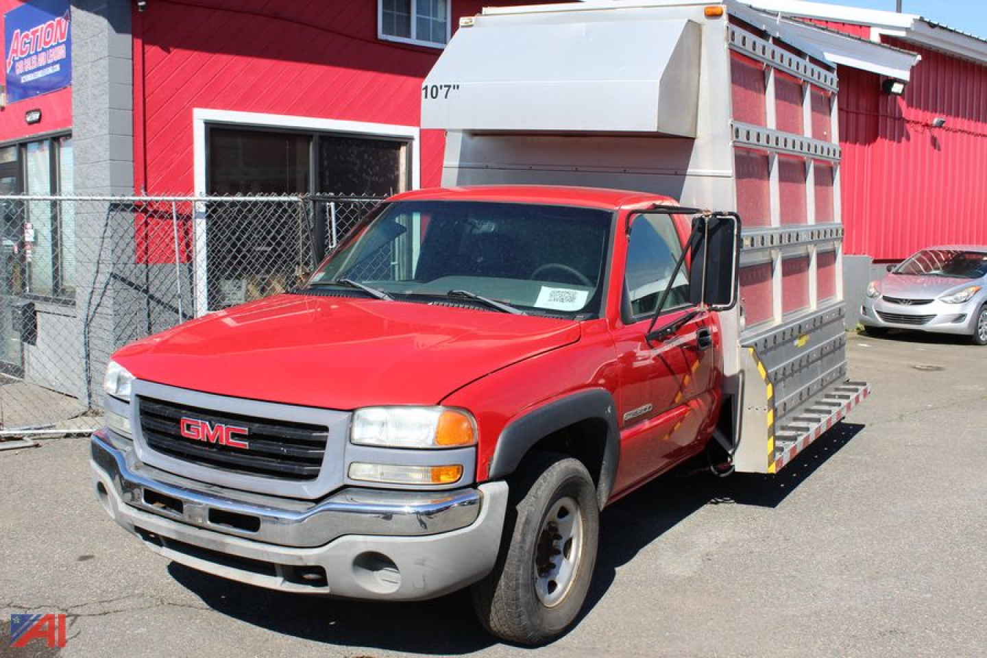 GMC Sierra 2500HD chassis cab truck with red cab and aluminum service body, front view.