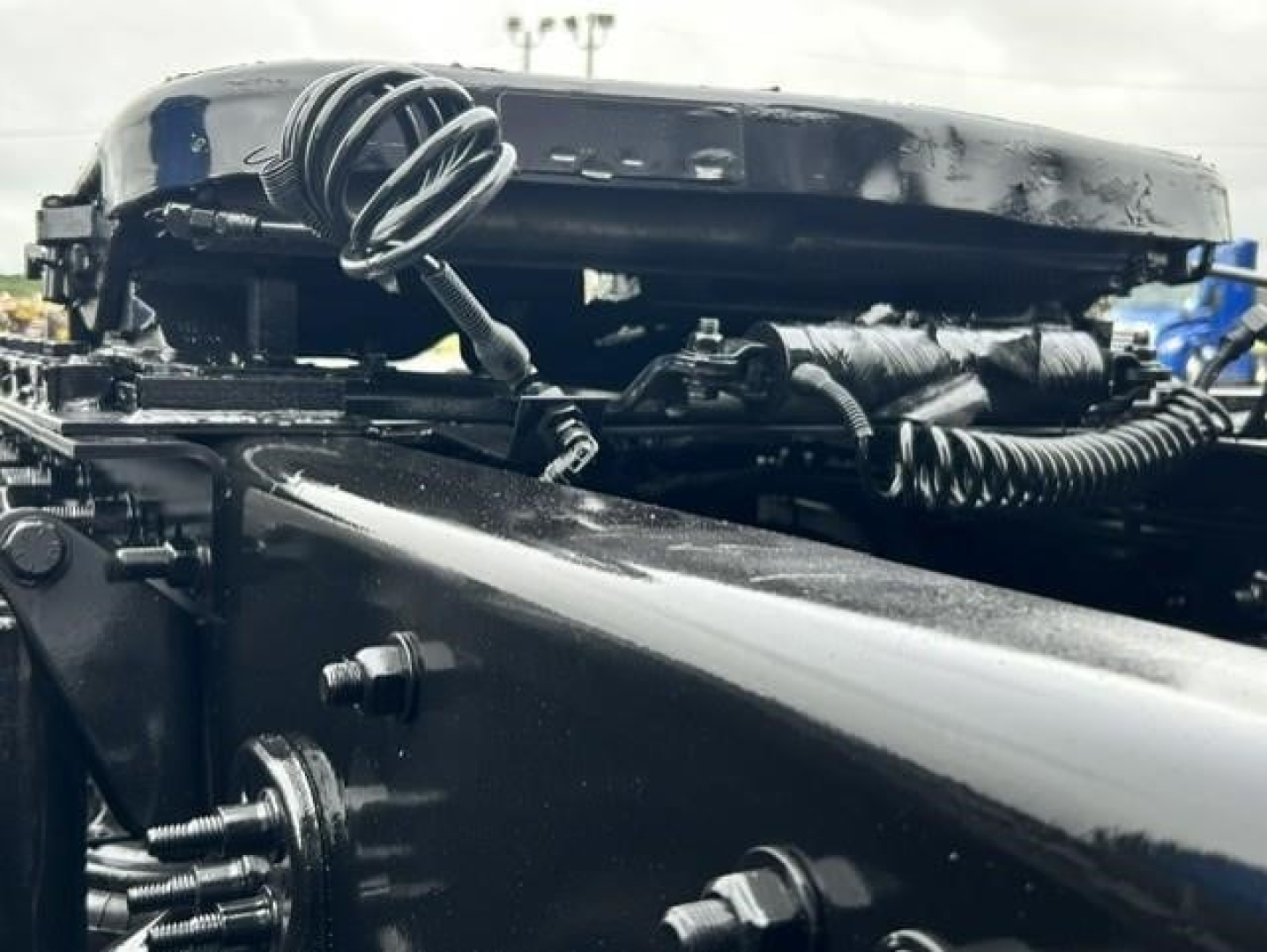 Truck chassis and frame showing wiring and hoses in engine bay area of 2022 Freightliner Cascadia 126.