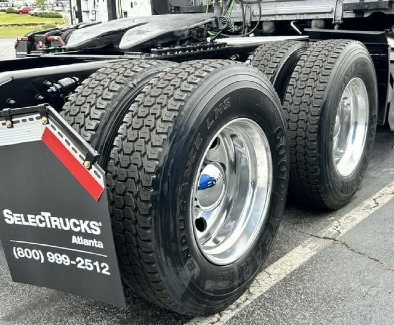 Freightliner Cascadia 126 rear dual-axle wheels and tires visible with chrome rims and mudflap showing SelectTrucks Atlanta contact number