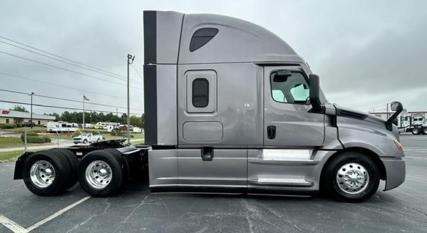 Vehicle side profile showing a 2022 Freightliner Cascadia 126 sleeper tractor in gray with twin rear axles and aerodynamic design.