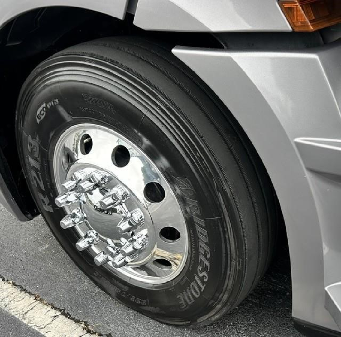 Truck wheel of a 2022 Freightliner Cascadia 126 showing polished chrome hub, lug nuts, and Michelin tire with tread.