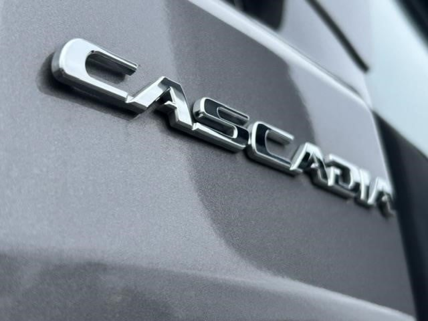 Cascadia badge on rear of Freightliner truck showing 'CASCADIA' chrome emblem.
