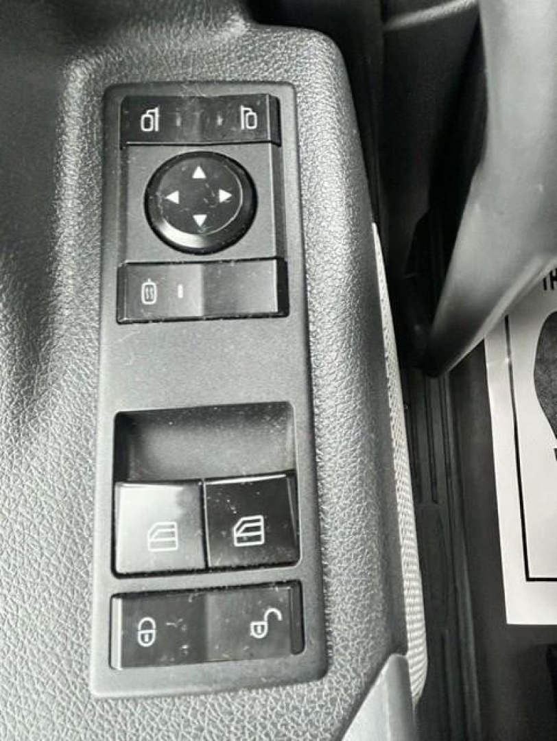 Controls panel with window/mirror adjustment buttons and lock switches inside a Freightliner Cascadia truck cab window control cluster.