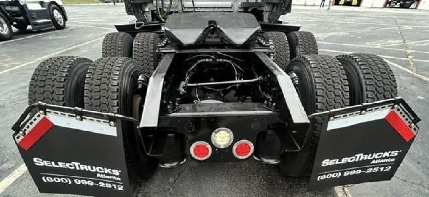 Rear view of Freightliner Cascadia 126 truck chassis showing dual rear axles, chassis frame, and mud flaps with SelectTrucks branding.