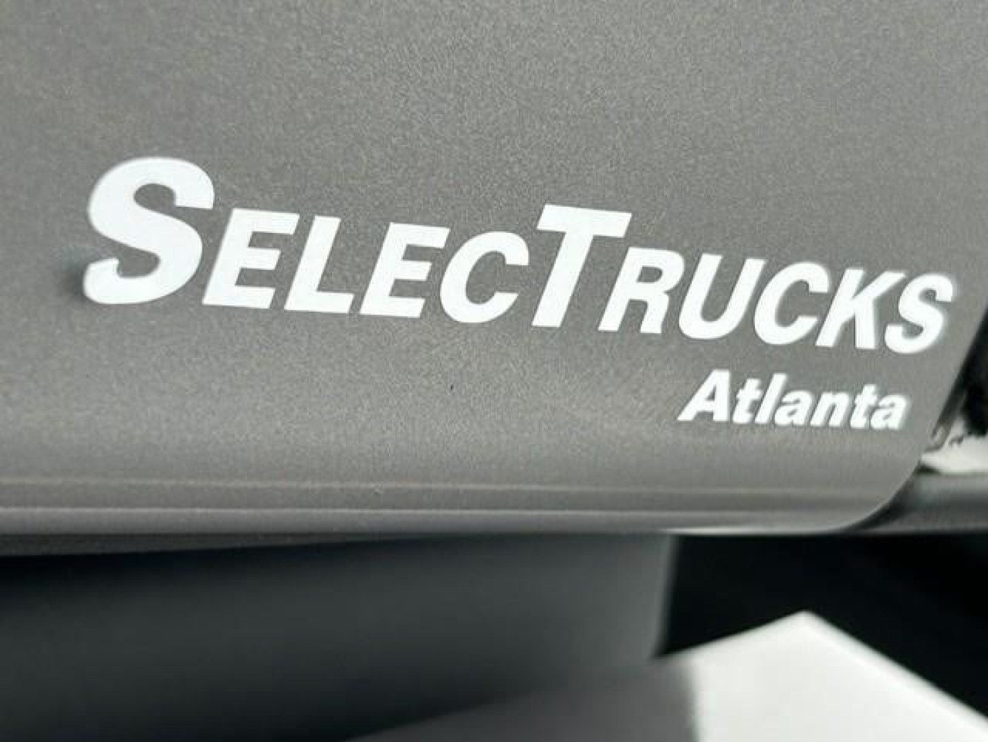 SelectTrucks Atlanta branding on a Freightliner Cascadia engine bay panel side with SelectTrucks logo