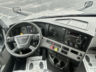 Dashboard and steering wheel view of a Freightliner Cascadia 126 truck cab showing instrument cluster, center console, and controls.