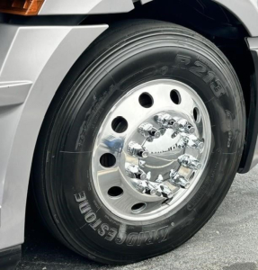 Truck front wheel and chrome hubcap of a Freightliner Cascadia 126 showing a Bridgestone tire and polished steel wheel.