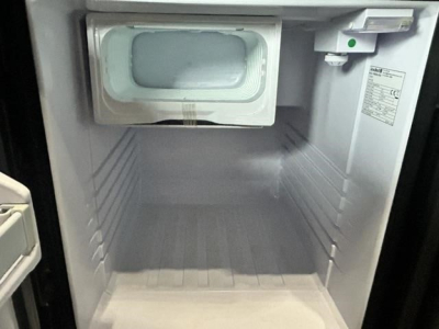 Freightliner Cascadia 126 icebox-style refrigerator in sleeper cab interior with blank freezer compartment.