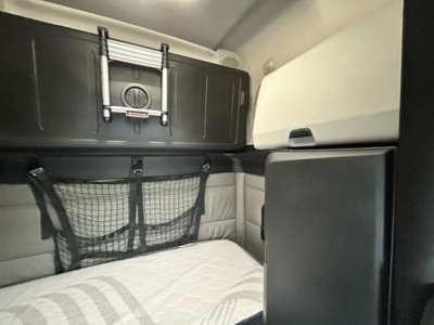 Freightliner Cascadia 126 sleeper cabin interior showing storage nets and bunk area.