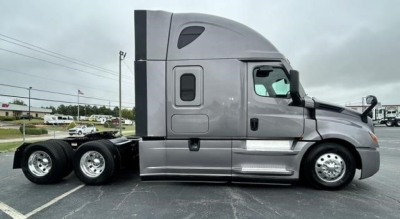 Vehicle side profile showing a 2022 Freightliner Cascadia 126 sleeper tractor in gray with twin rear axles and aerodynamic design.
