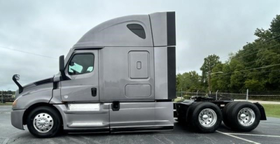 Truck side view showing Freightliner Cascadia 126 sleeper cabin and 6-wheel rear axle with chrome steps and fuel tanks.