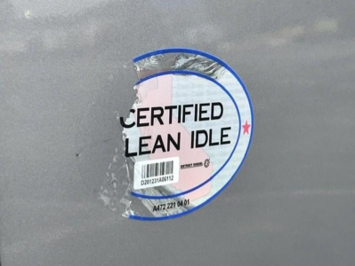 Sticker on Freightliner Cascadia showing certified clean idle seal with barcode and circular logo