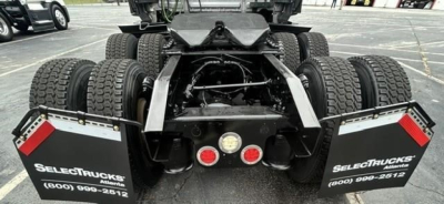 Rear view of Freightliner Cascadia 126 truck chassis showing dual rear axles, chassis frame, and mud flaps with SelectTrucks branding.
