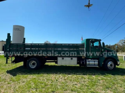 Truck bed and cab of a 2014 Kenworth T370 flatbed truck with aluminum storage boxes and fuel tank.