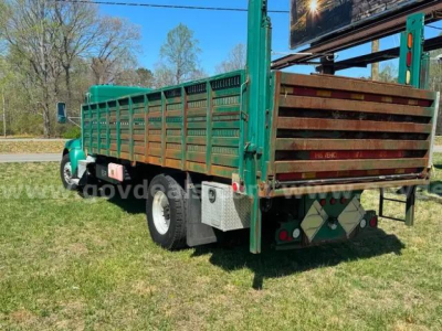 Kenworth T370 flatbed truck rear/side view showing green cargo bed and wooden tailgate, stock number 23084-20, VIN 2NKHHM7AXEM386405.