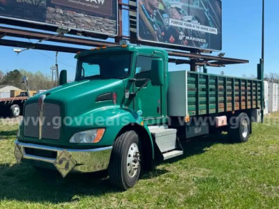 Kenworth T370 flatbed truck in green, front-left view showing cab, bumper, and side rails.