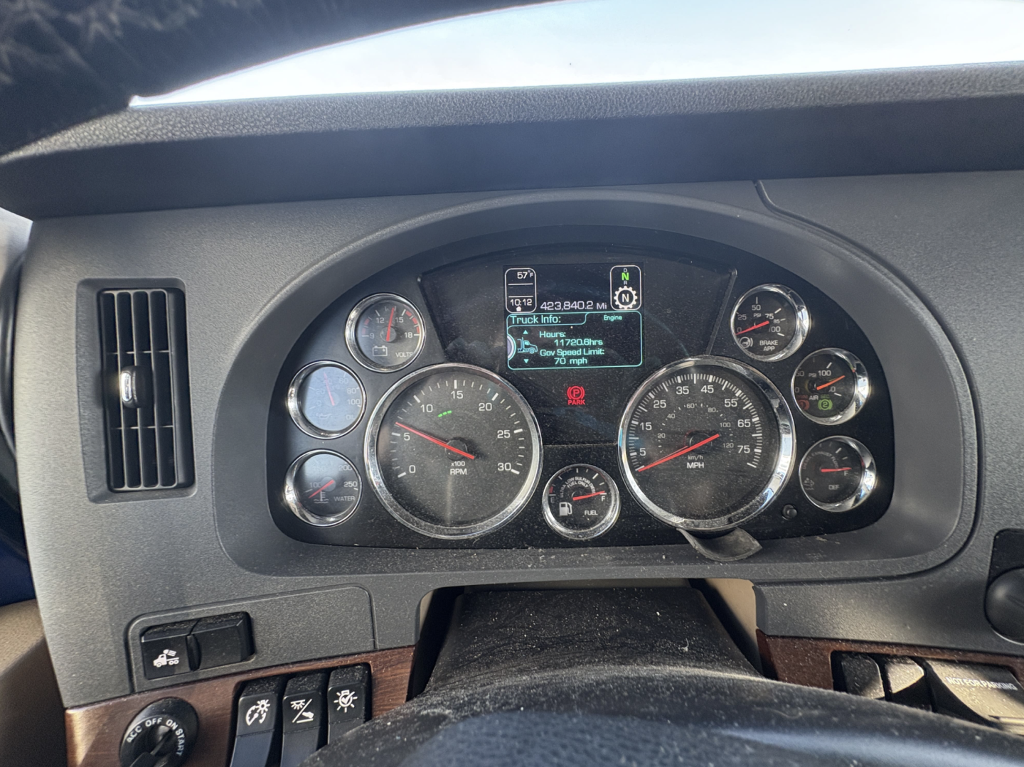 Dashboard of a Kenworth T680 truck showing instrument cluster and digital display with various gauges and warning icons.