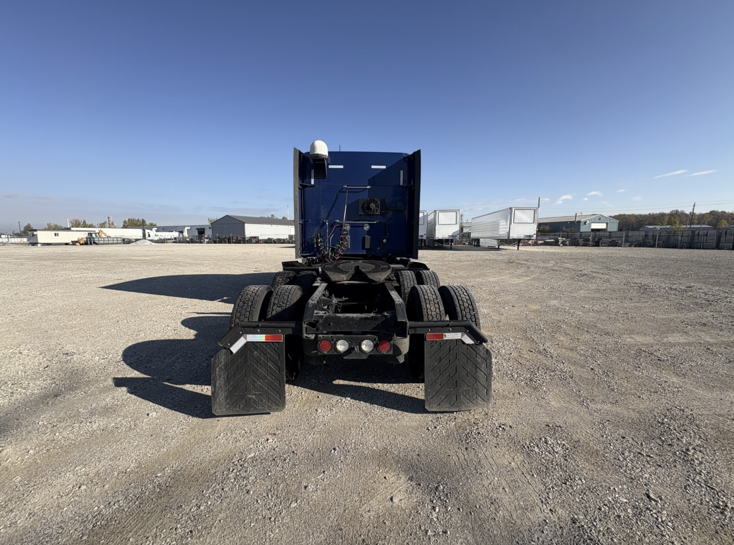 Kenworth T680 chassis rear view showing mud flaps and rear lights.