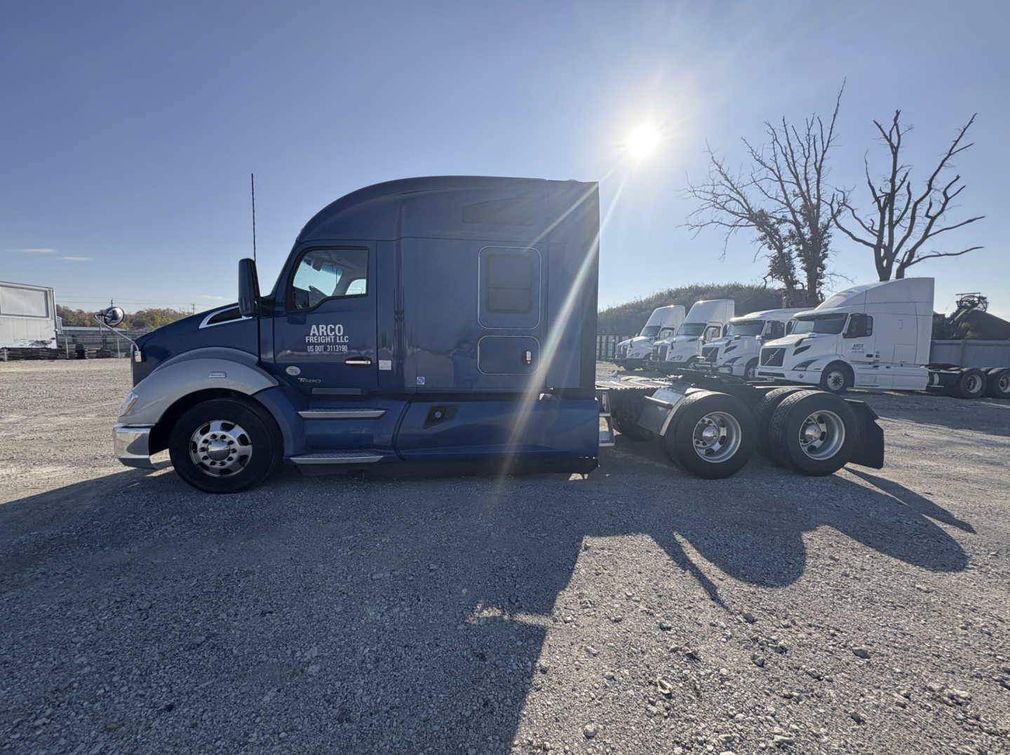 Kenworth T680 tractor in blue with sleeper cab, side text reads ARCO?, front wheel, trailer attached, many other trucks in background, VIN visible in listing not on image