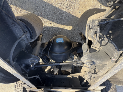 Kenworth T680 rear suspension view with air system and center axle housing. Visible are air springs, drive shaft, differential housing, and ladder frame undercarriage.