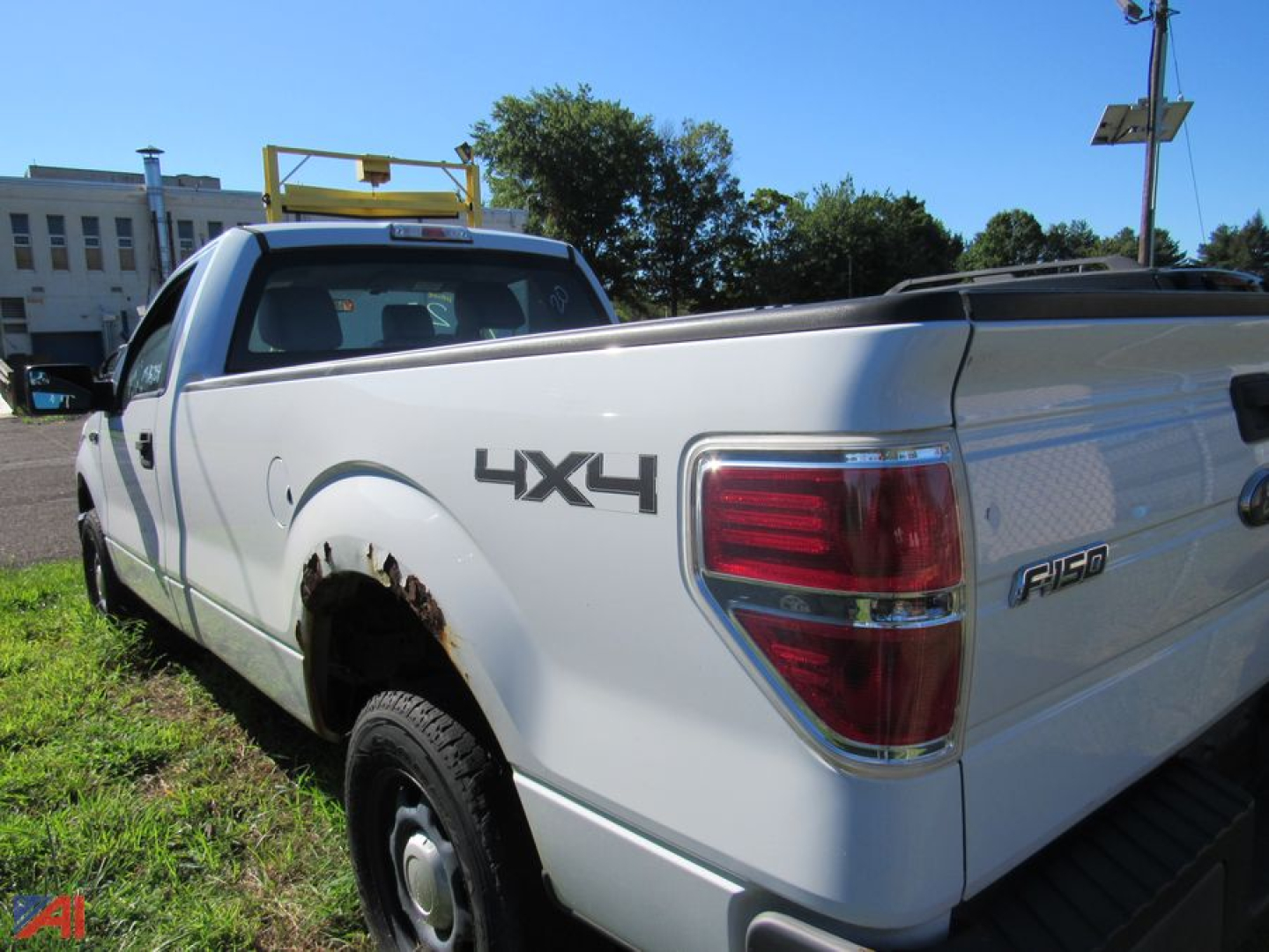 Ford F-150 pickup truck 4x4 rear quarter view showing bed, taillight, 4X4 badge, and stickered cargo area