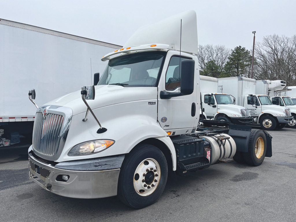 International RH613 daycab truck in a lot showing front view with sleeper cab and dual rear wheels.